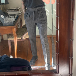 Person wearing high-waisted grey pleated trousers from Addicted Bespoken taking a mirror selfie in a classic wooden-framed mirror