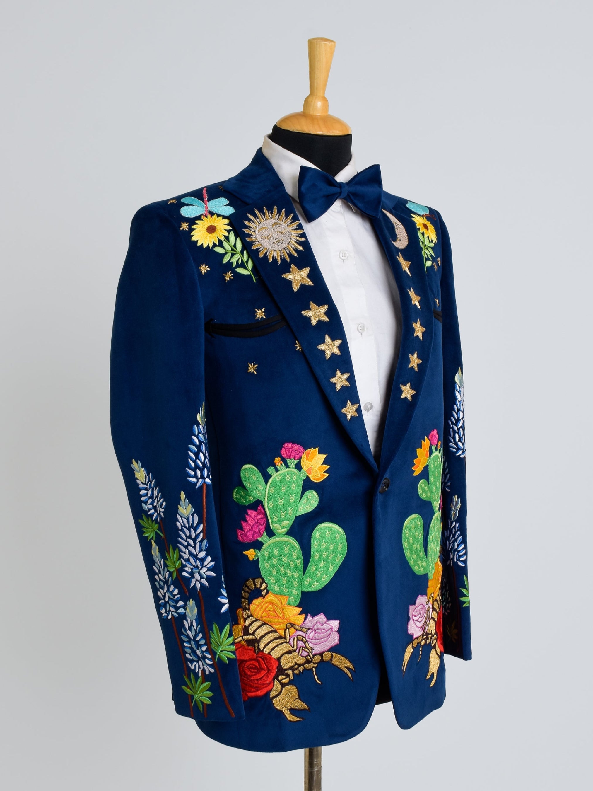 A classic country western suit featuring a tailored jacket with peaked lapels, adorned with intricate embroidery and fringe details.