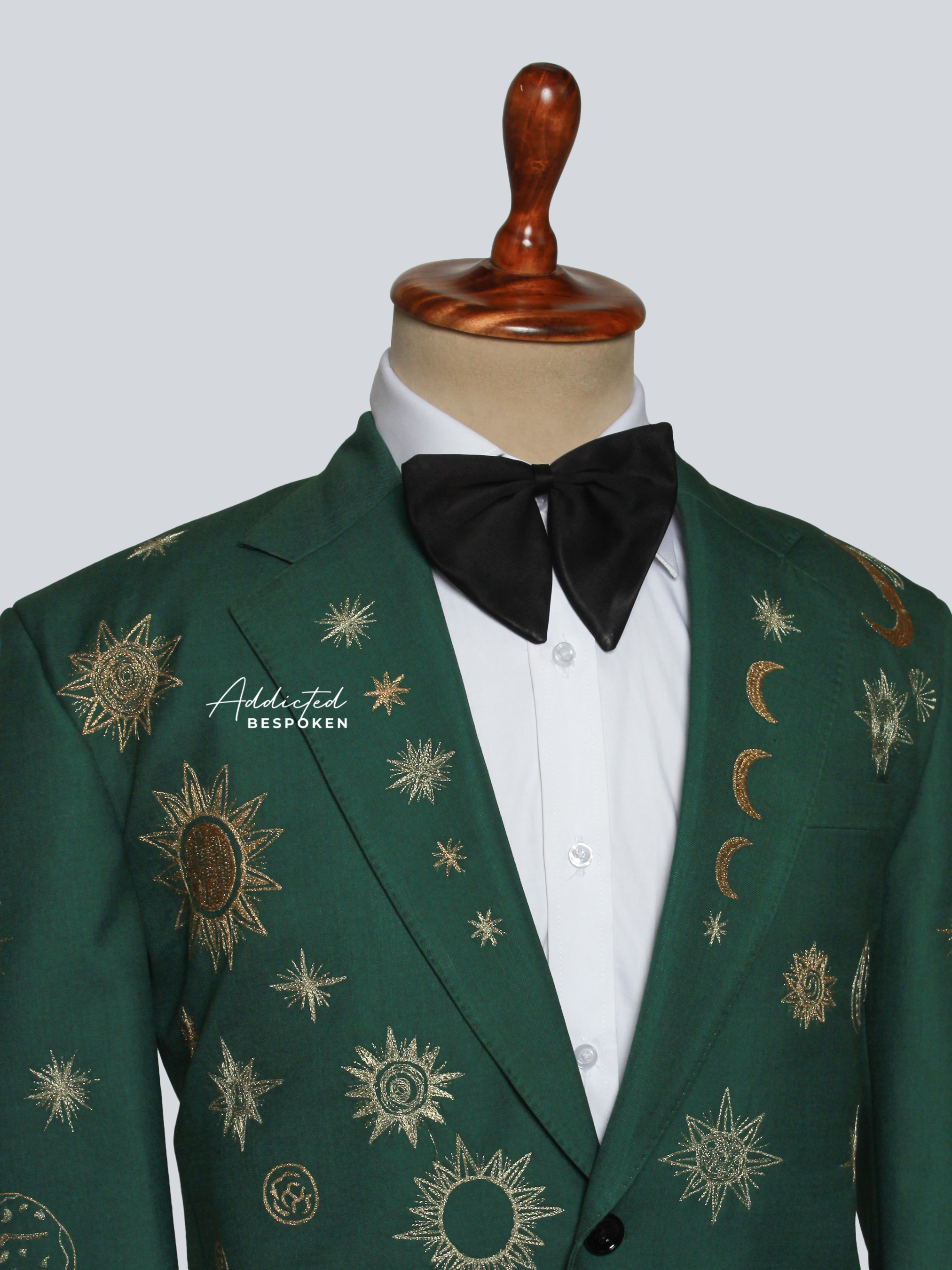 Green embroidered jacket with a black bow tie on a mannequin against a gray background
