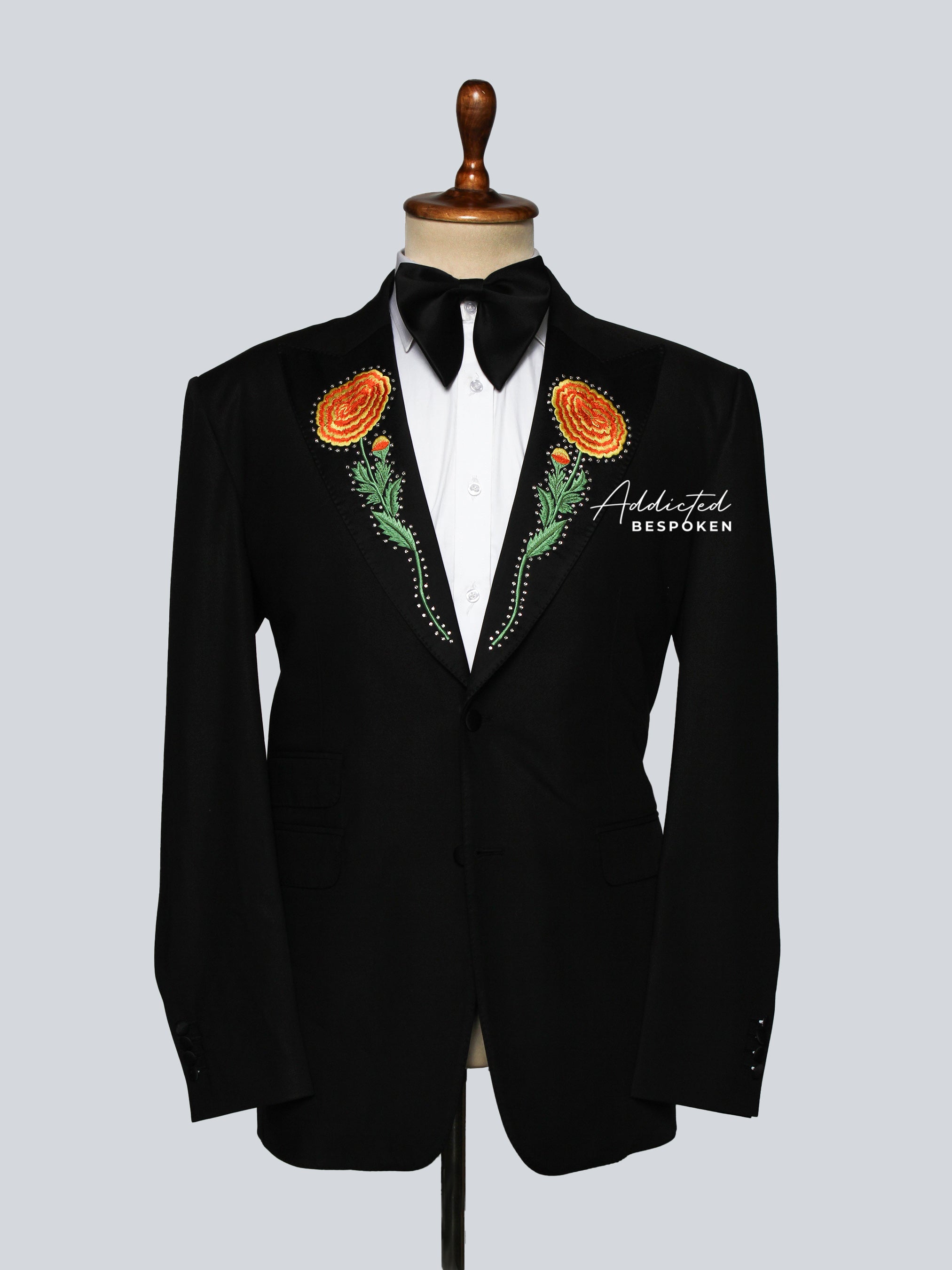 Black tuxedo with floral embroidery on the lapel on a mannequin against a light gray background