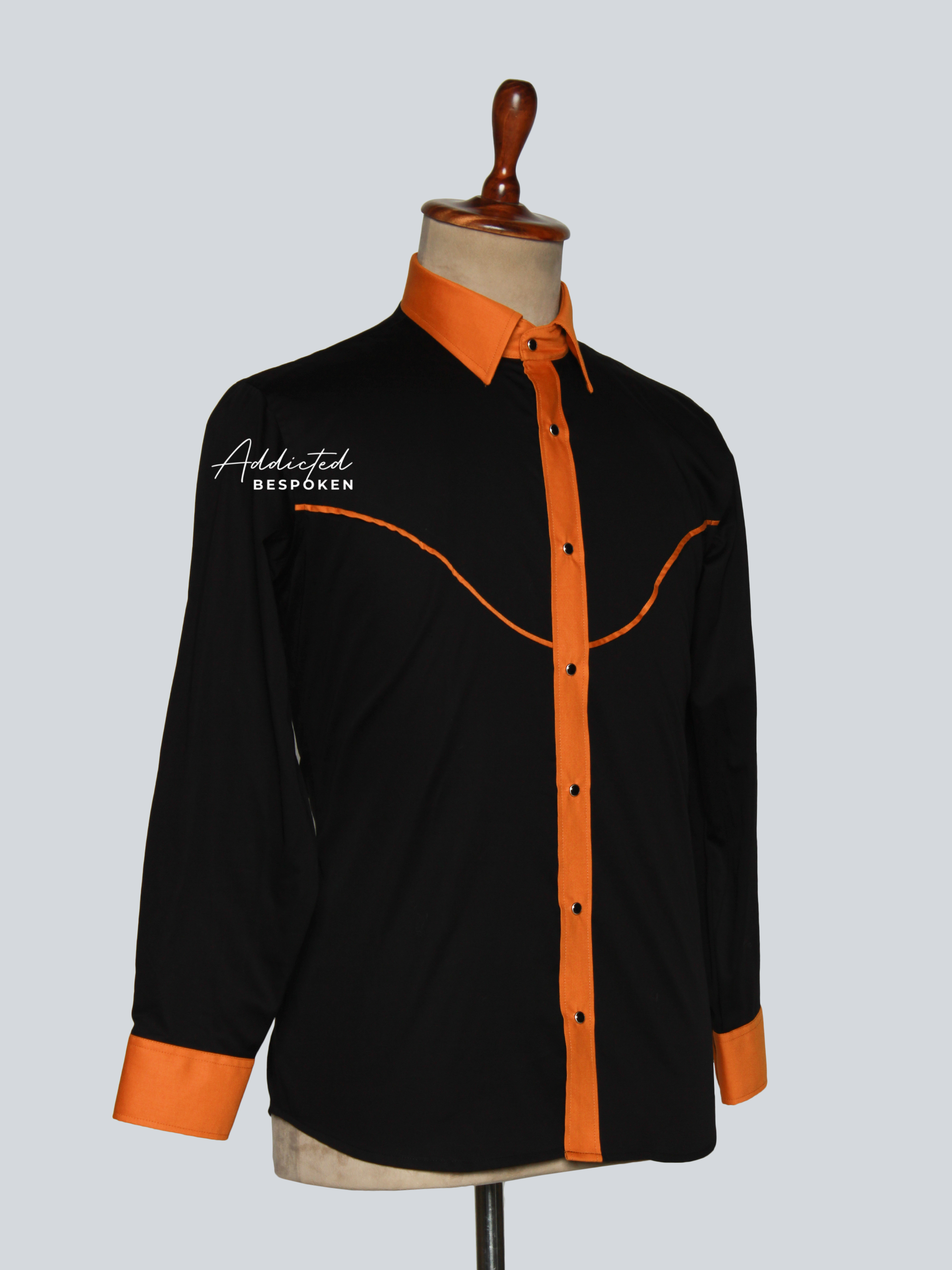 Angled side view of black western shirt with orange piping and buttons – Addicted Bespoken