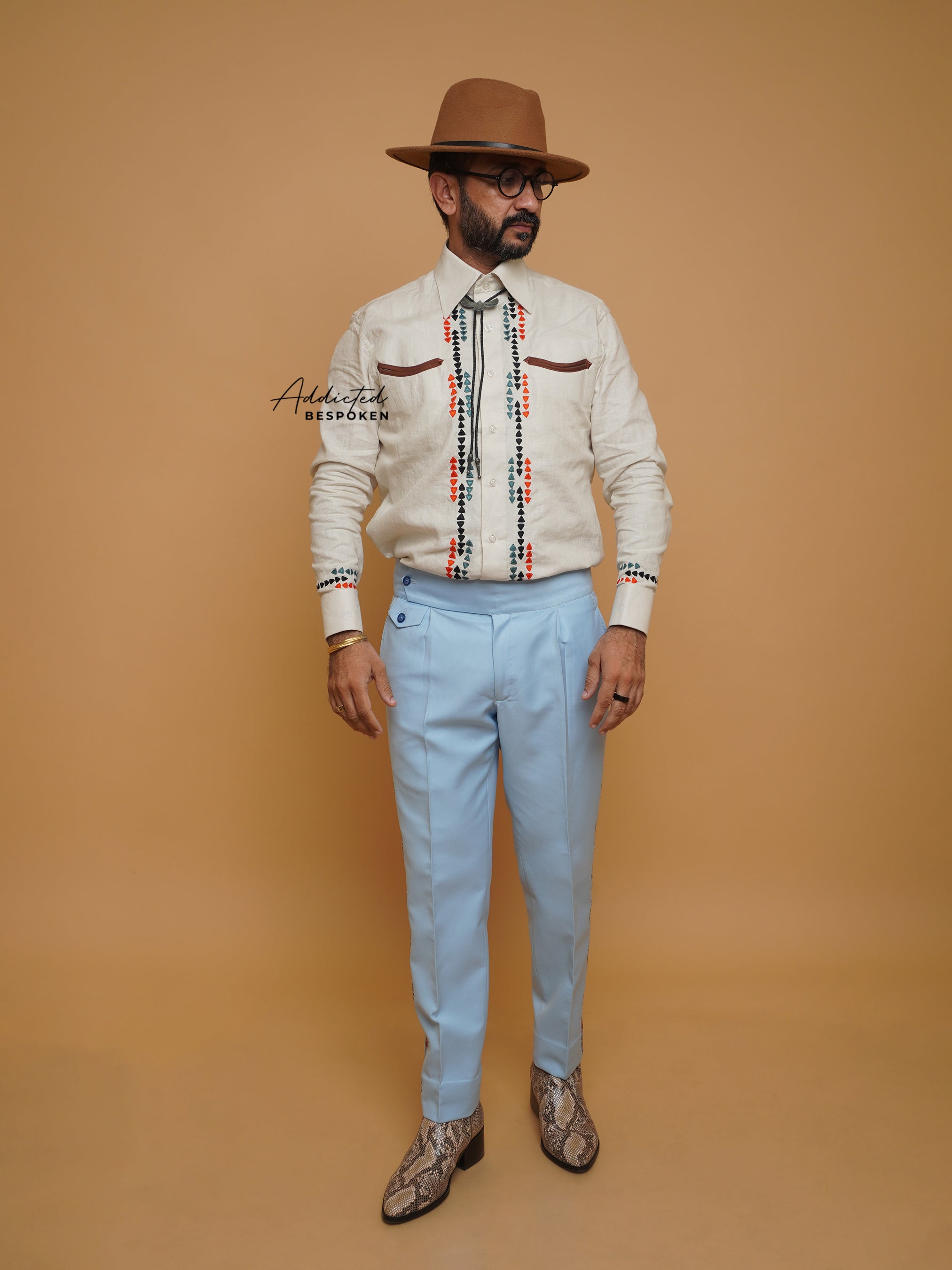 Full body view of male model in cream embroidered shirt with blue trousers and hat β Addicted Bespoken