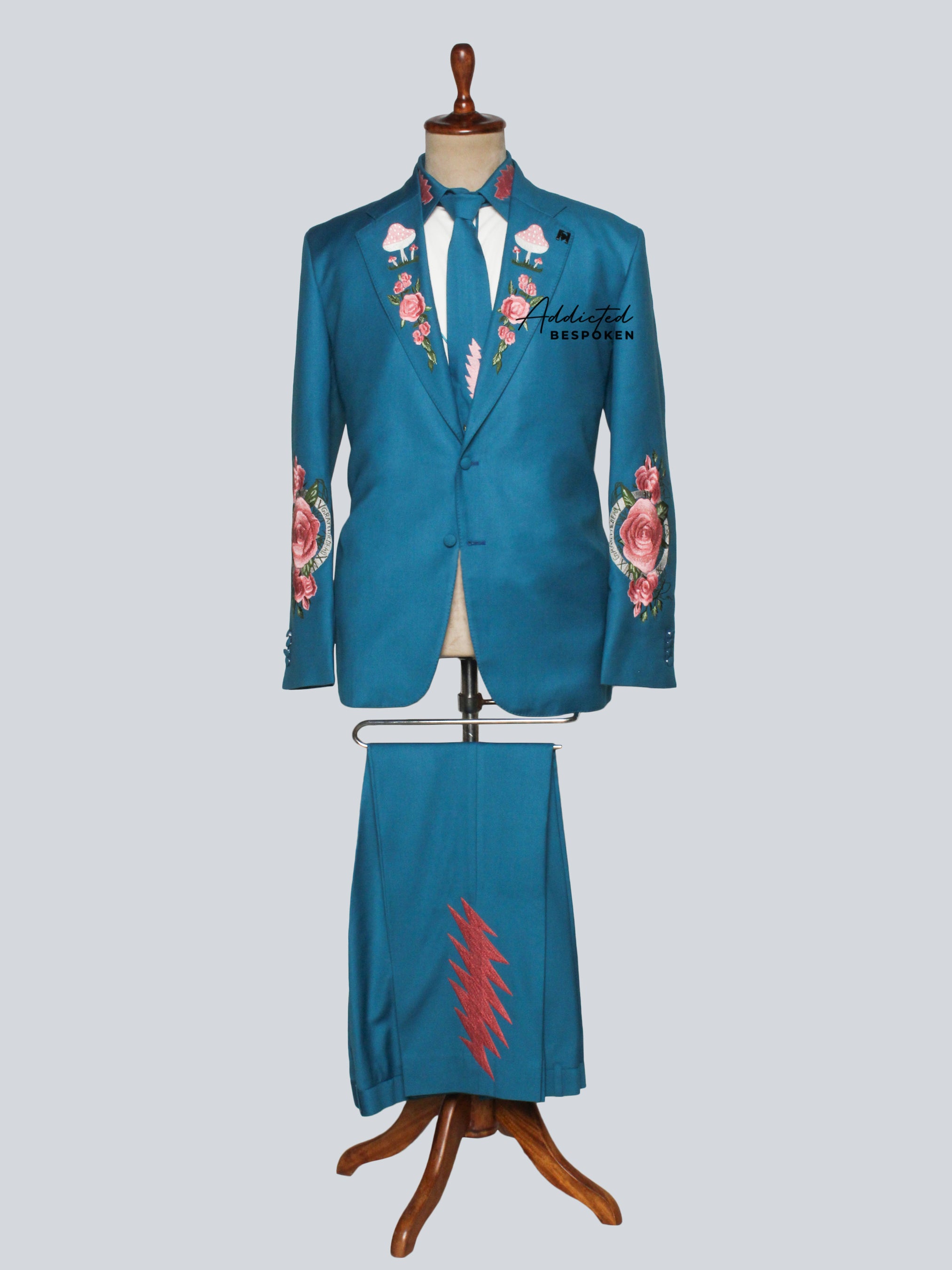 A floral-themed suit with blue base and floral embroidery, displayed on a mannequin.