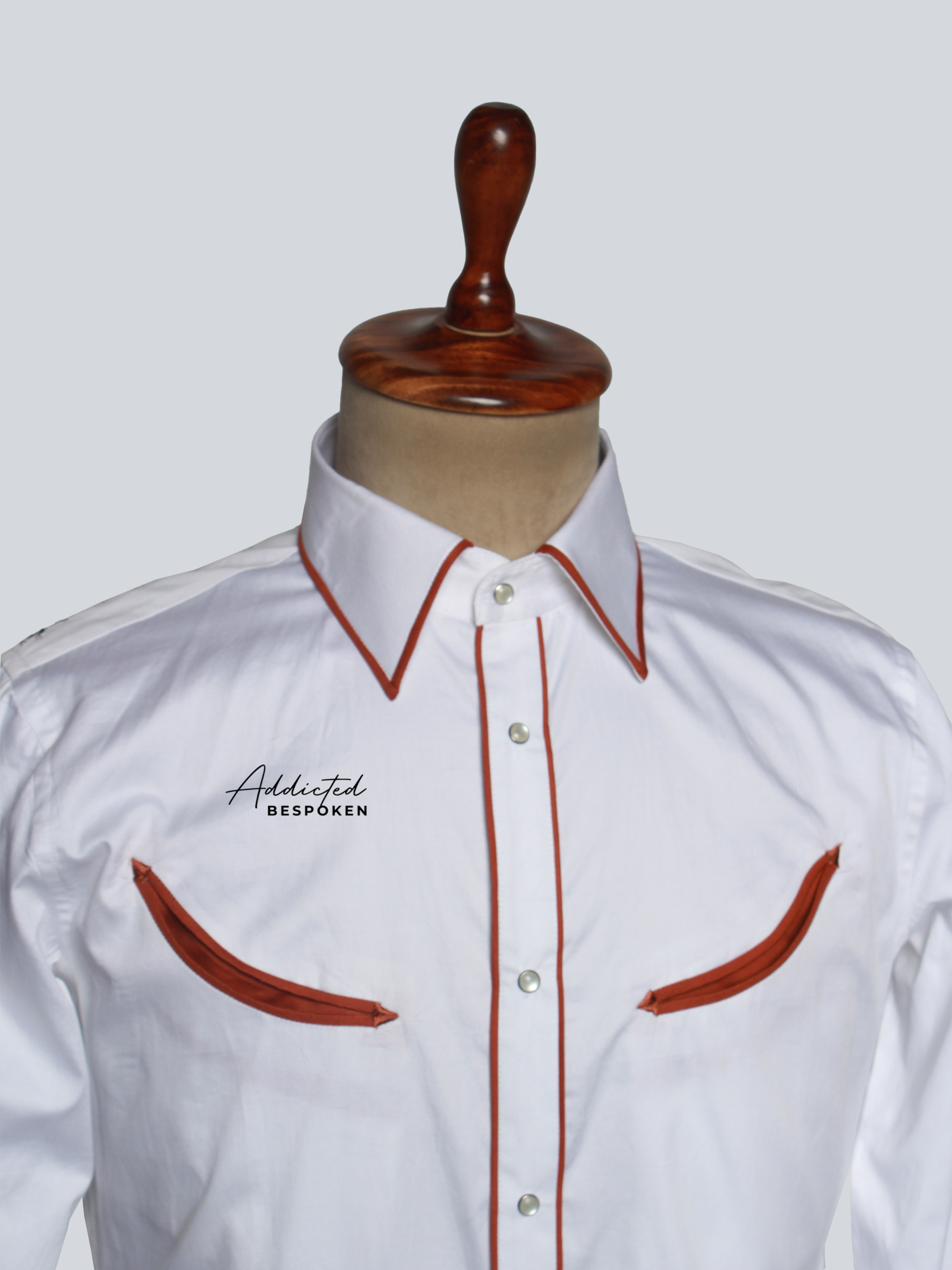 Close-up angled view of chest embroidery on white western shirt with red piping – Addicted Bespoken
