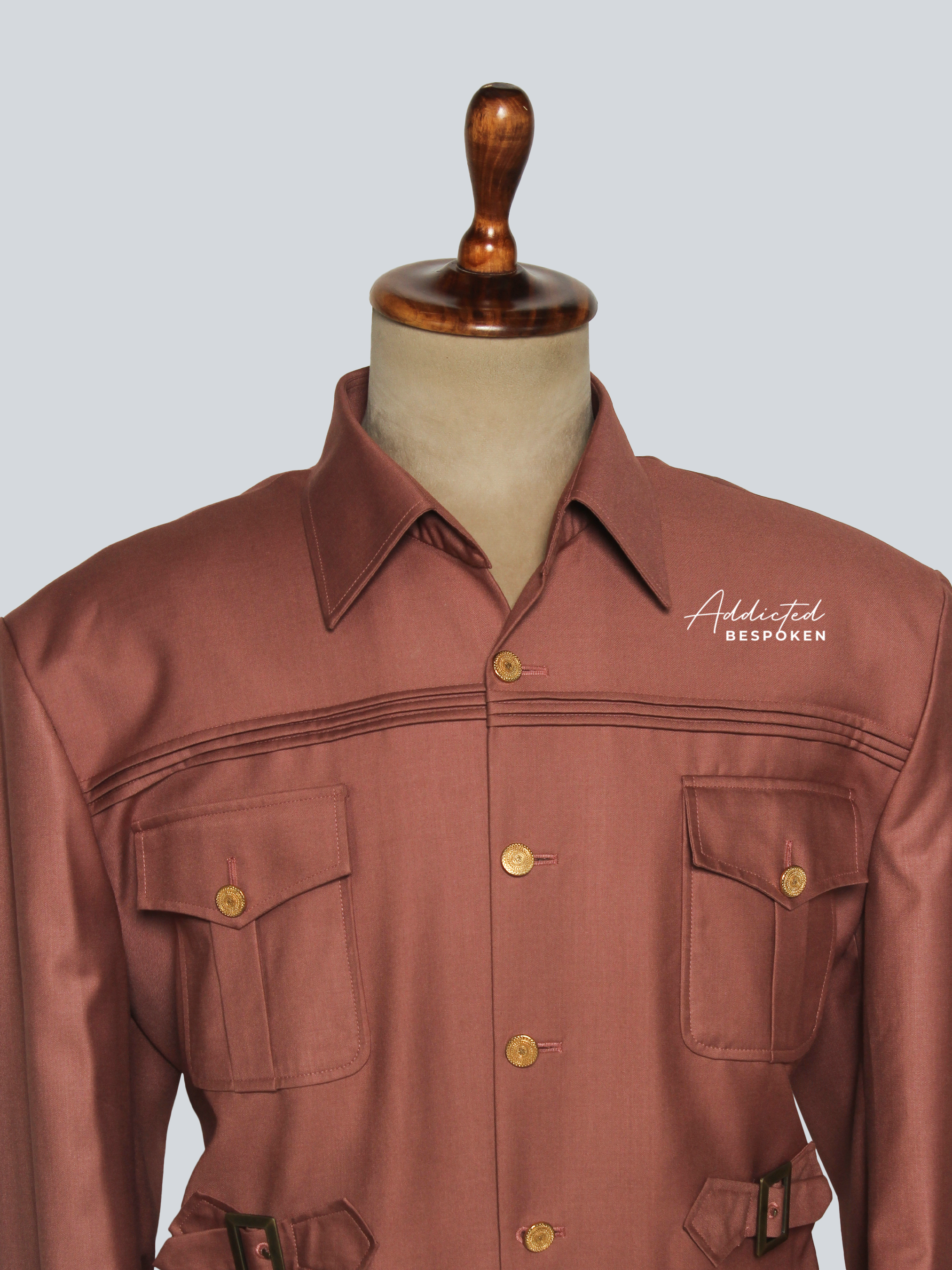 Iconic safari suit lapel close-up โ brown tailored safari jacket with sharp collar and gold button detail