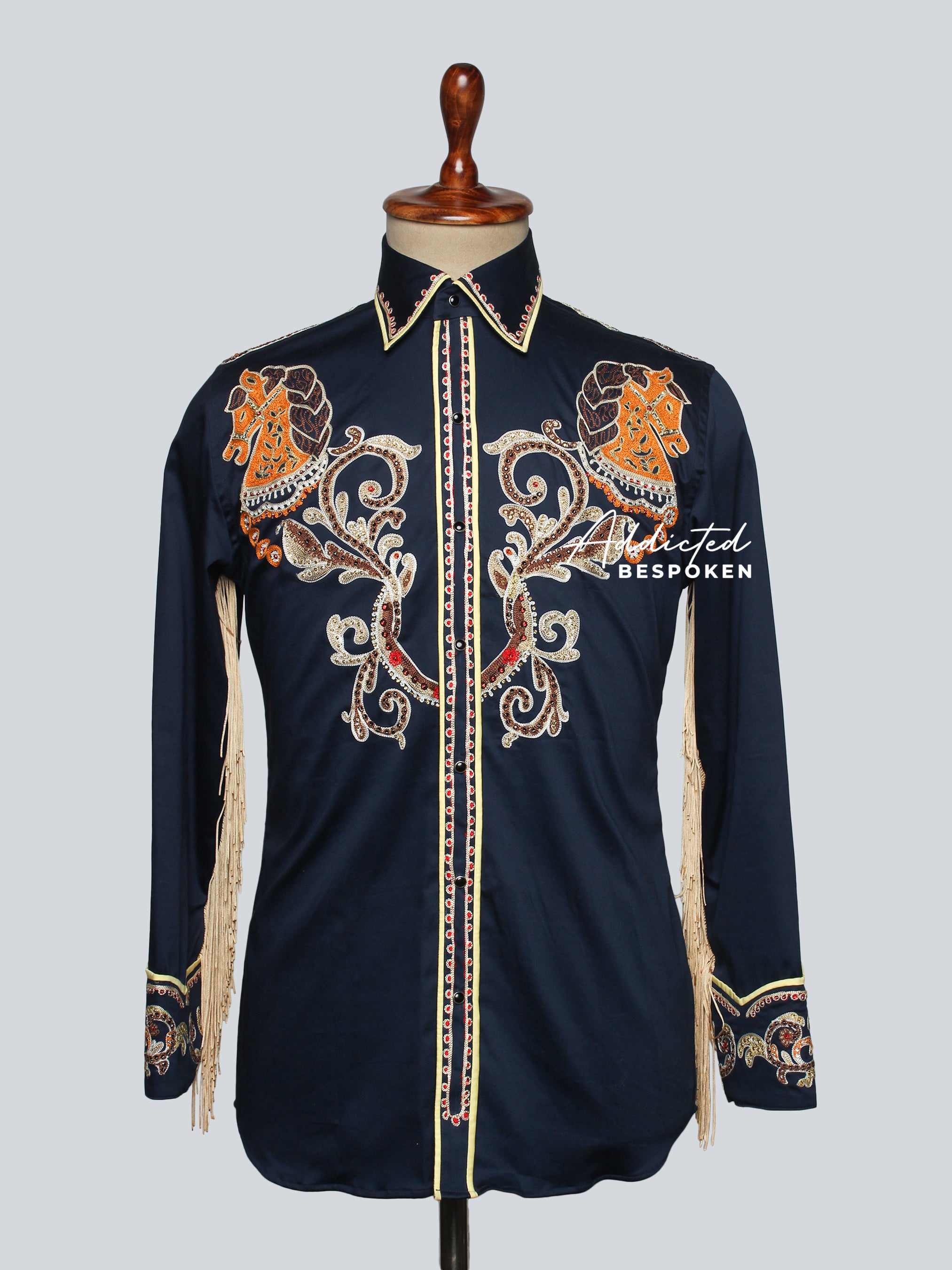 A blue long-sleeved men's cowboy shirt with detailed fringes and embroidery, designer cuffs, and a button closure.