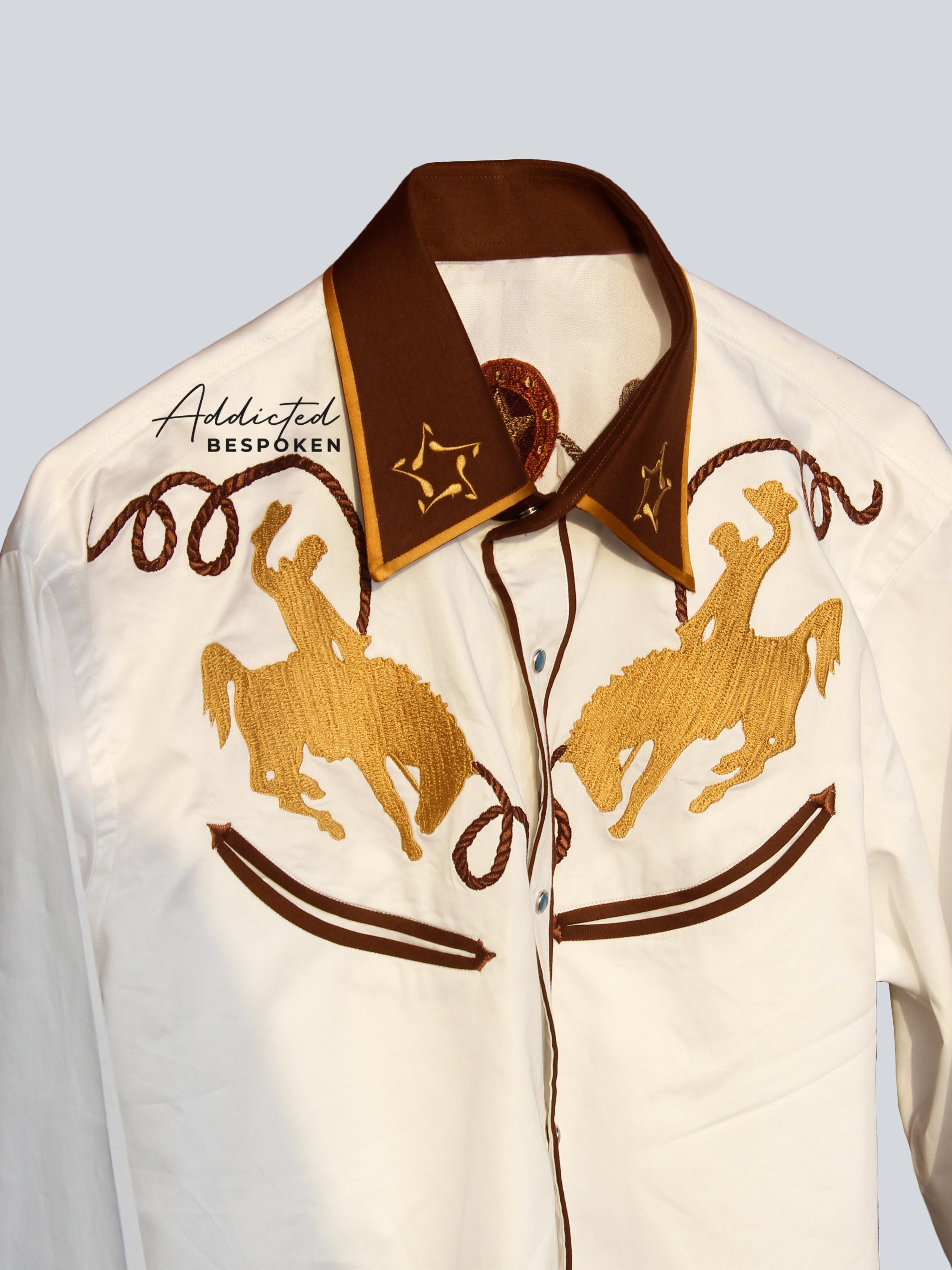 Angled side view of cream shirt with brown piping and horse embroidery β Addicted Bespoken