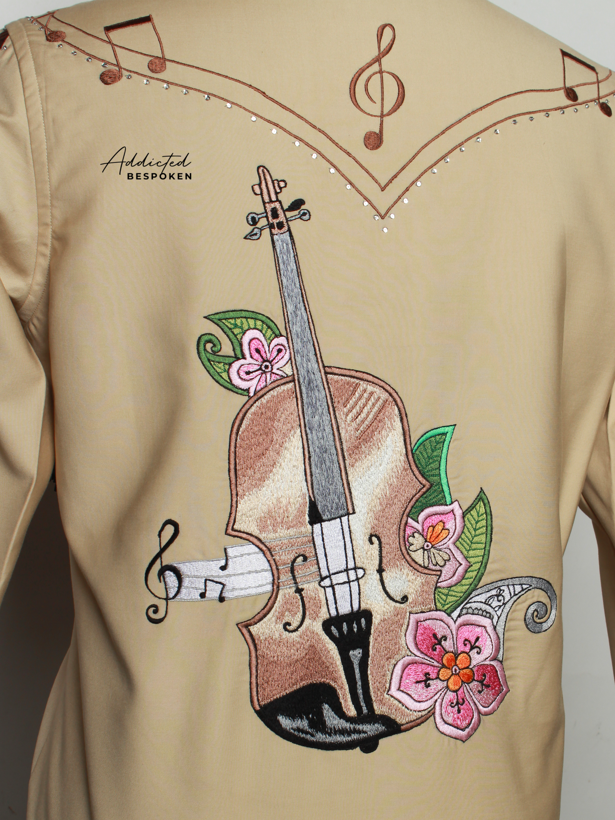 Close-up of musical instrument and floral embroidery on tan western shirt – Addicted Bespoken