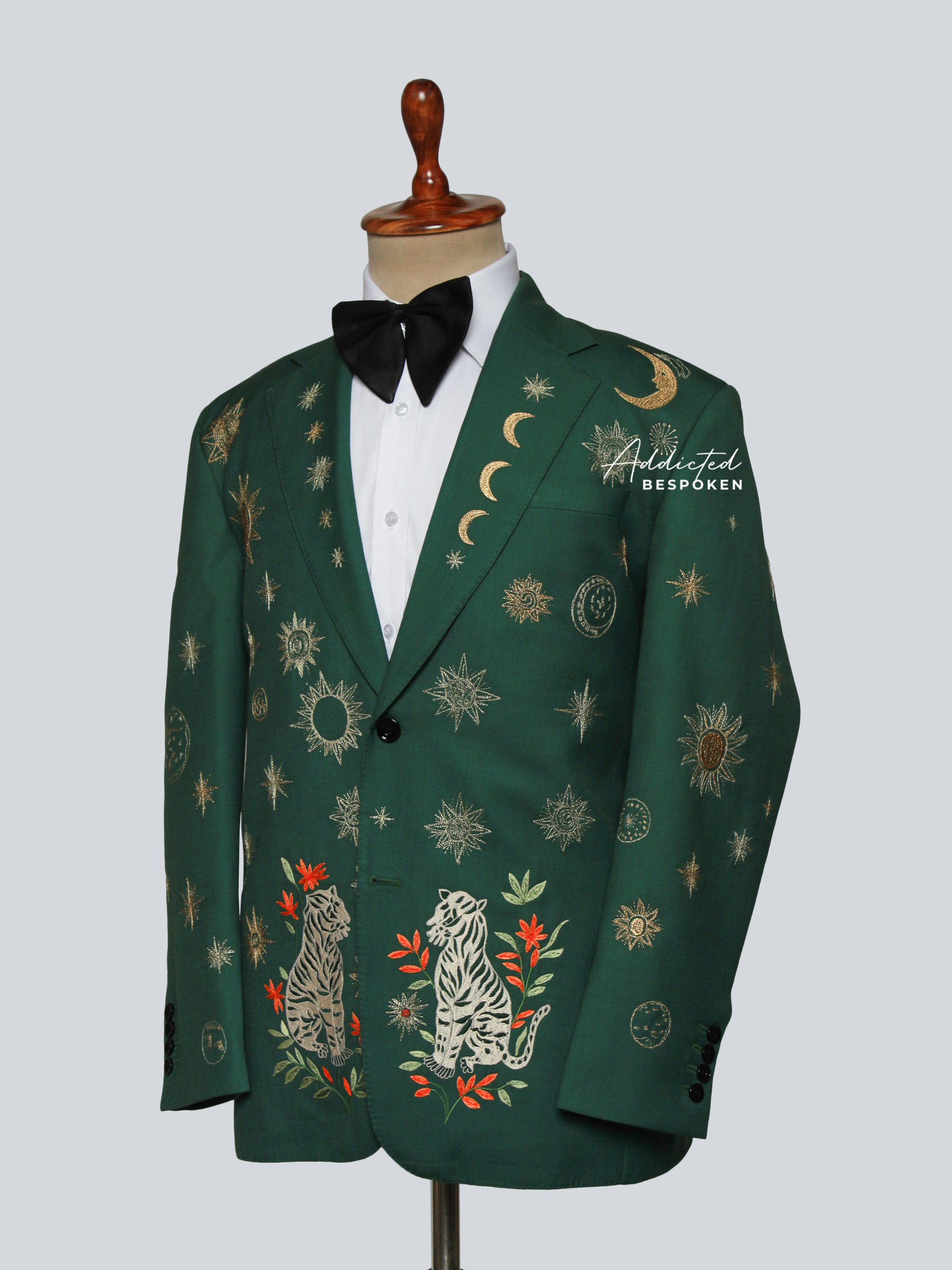 Green embroidered blazer on a mannequin with a white shirt and black bow tie.