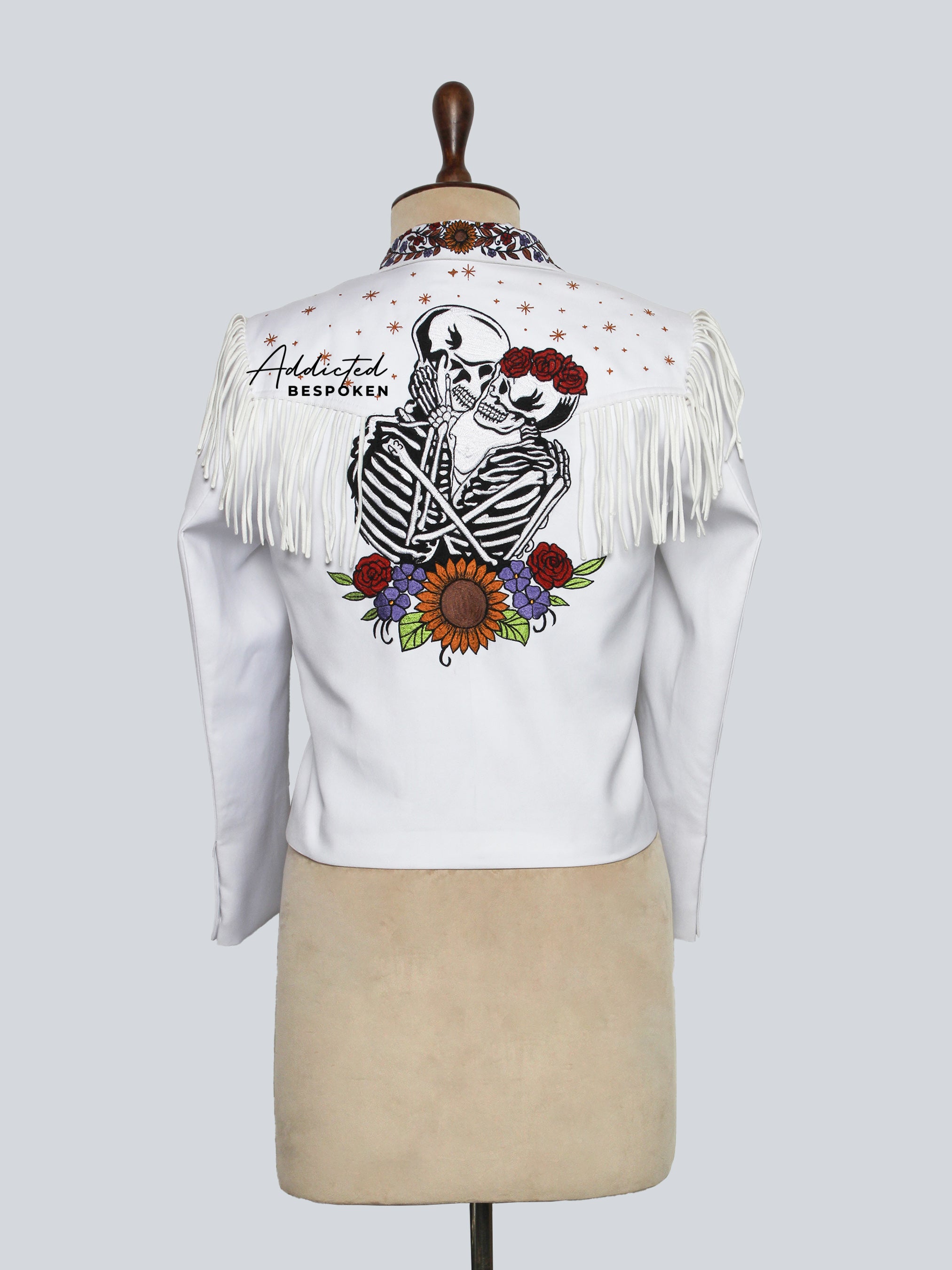 Back View of White jacket with a skeleton design and fringes on a mannequin against a white background