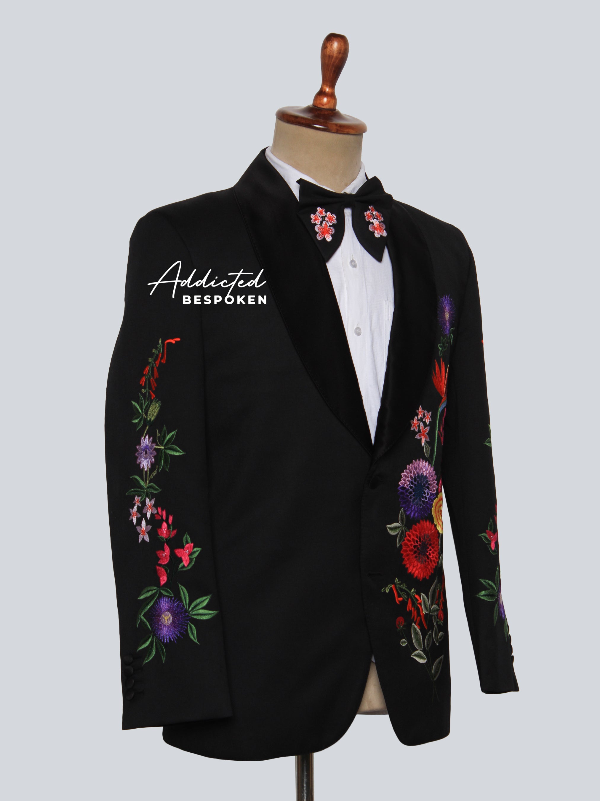 Side view of black blazer featuring multicolor floral embroidery on lapel and sleeve