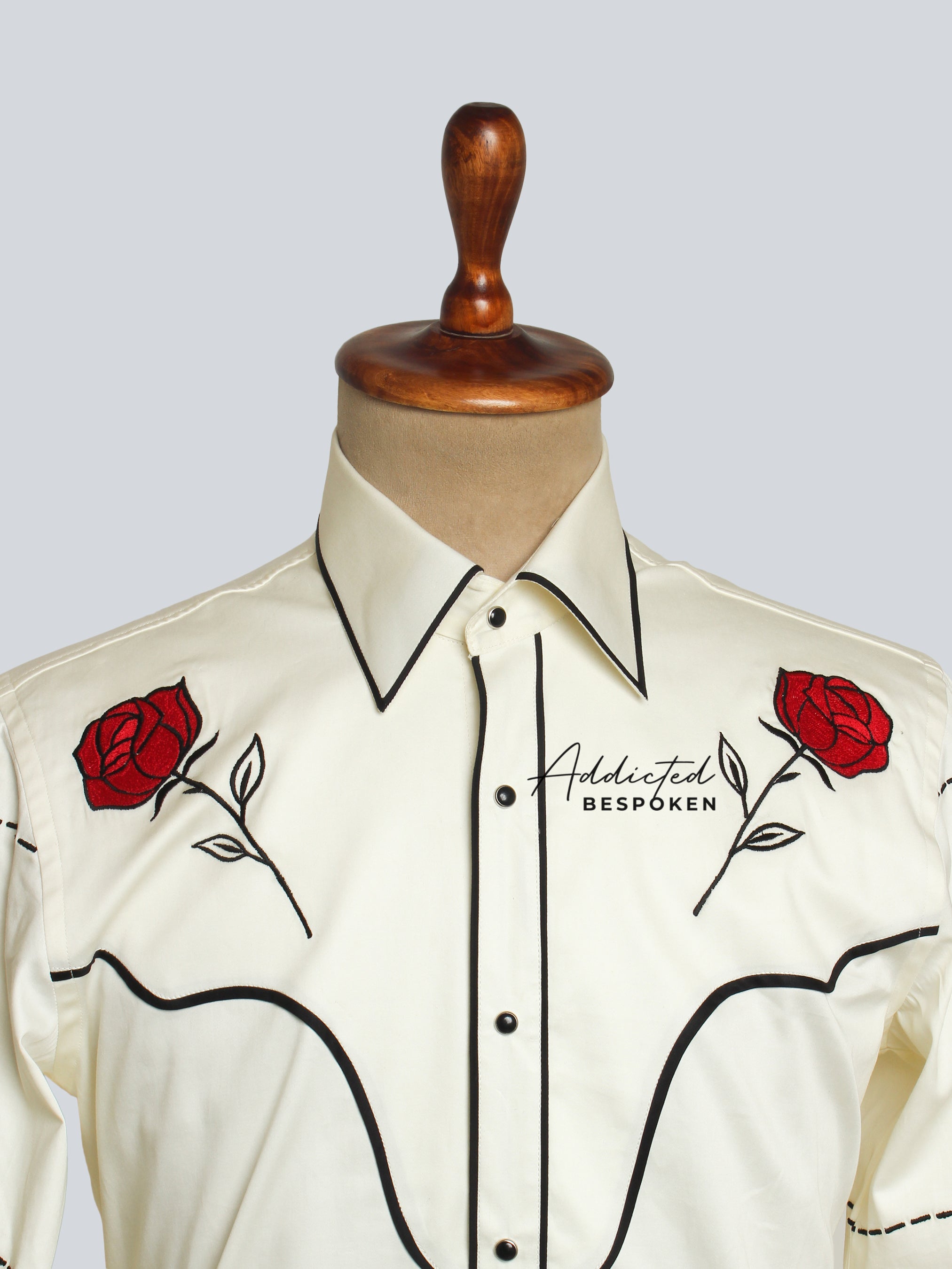 Close-up chest view of cream shirt with red floral embroidery and black piping โ Addicted Bespoken