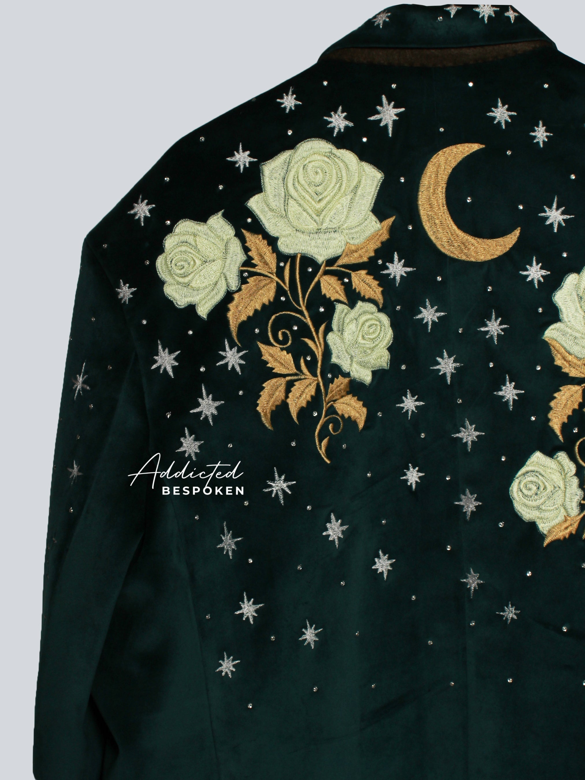 Detailed embroidery of golden flowers and moon with star accents on green blazer sleeve
