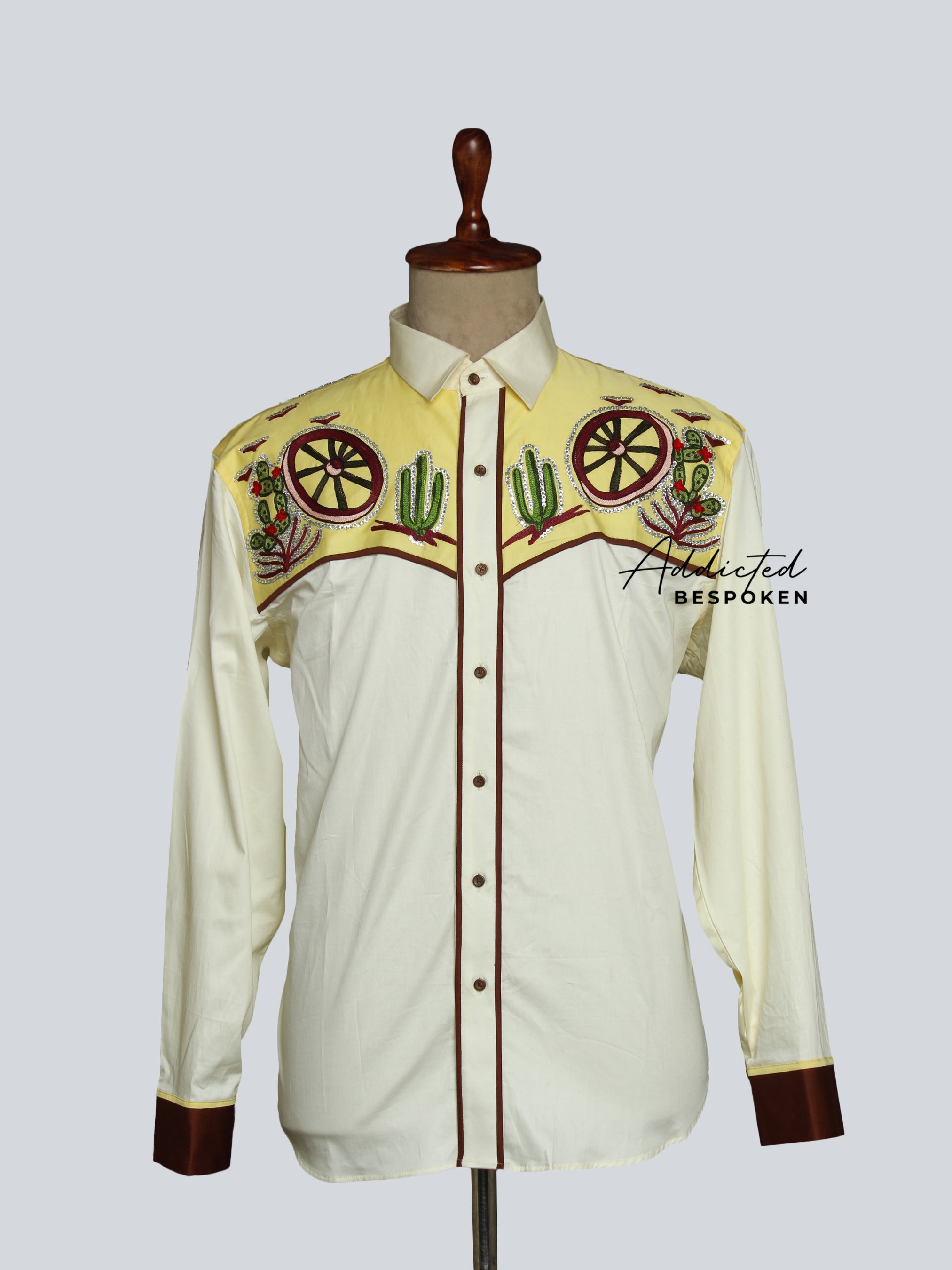 A white long-sleeved Western shirt with floral embroidery, featuring a collared neckline and button closures.