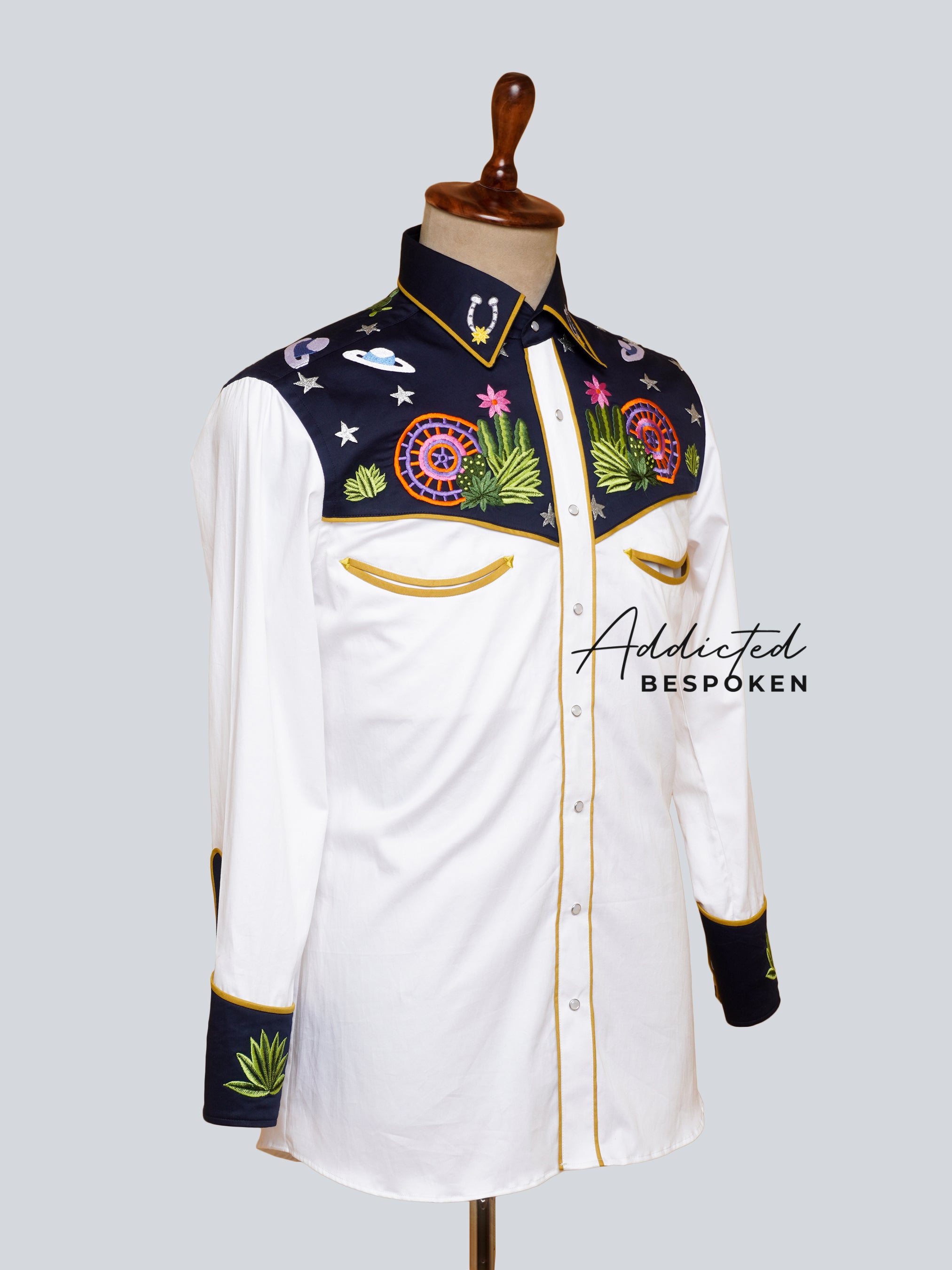 Angled side view of white western shirt with floral embroidery and contrast black cuffs – Addicted Bespoken