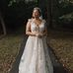 Bride wearing a flowing white wedding gown from Addicted Bespoken standing outdoors in a natural setting