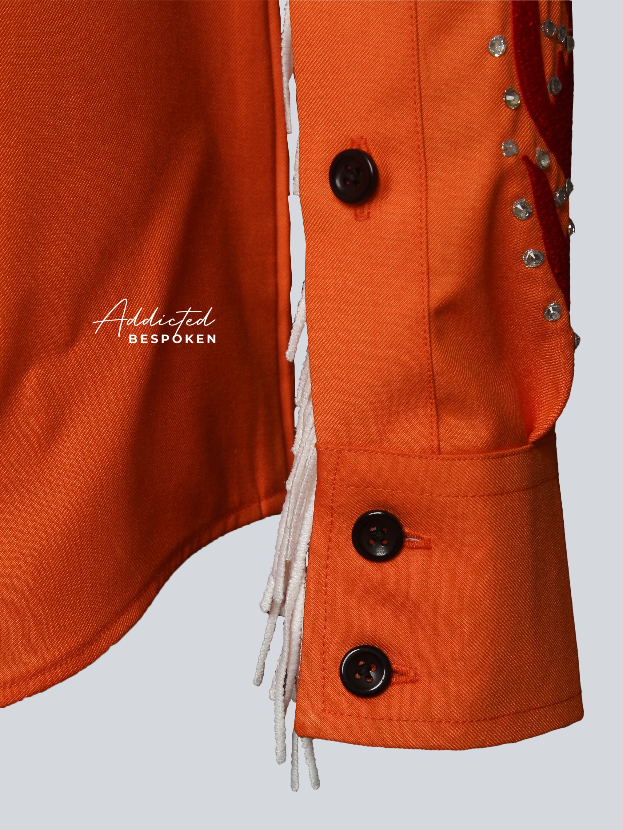 Close-up of embroidered sleeves on orange western shirt โ Addicted Bespoken