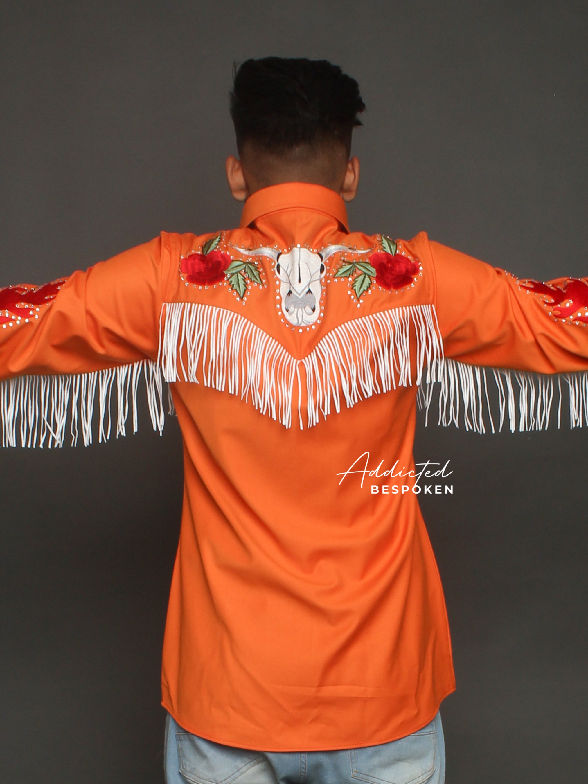 Back view of male model wearing orange embroidered western shirt with fringe โ Addicted Bespoken