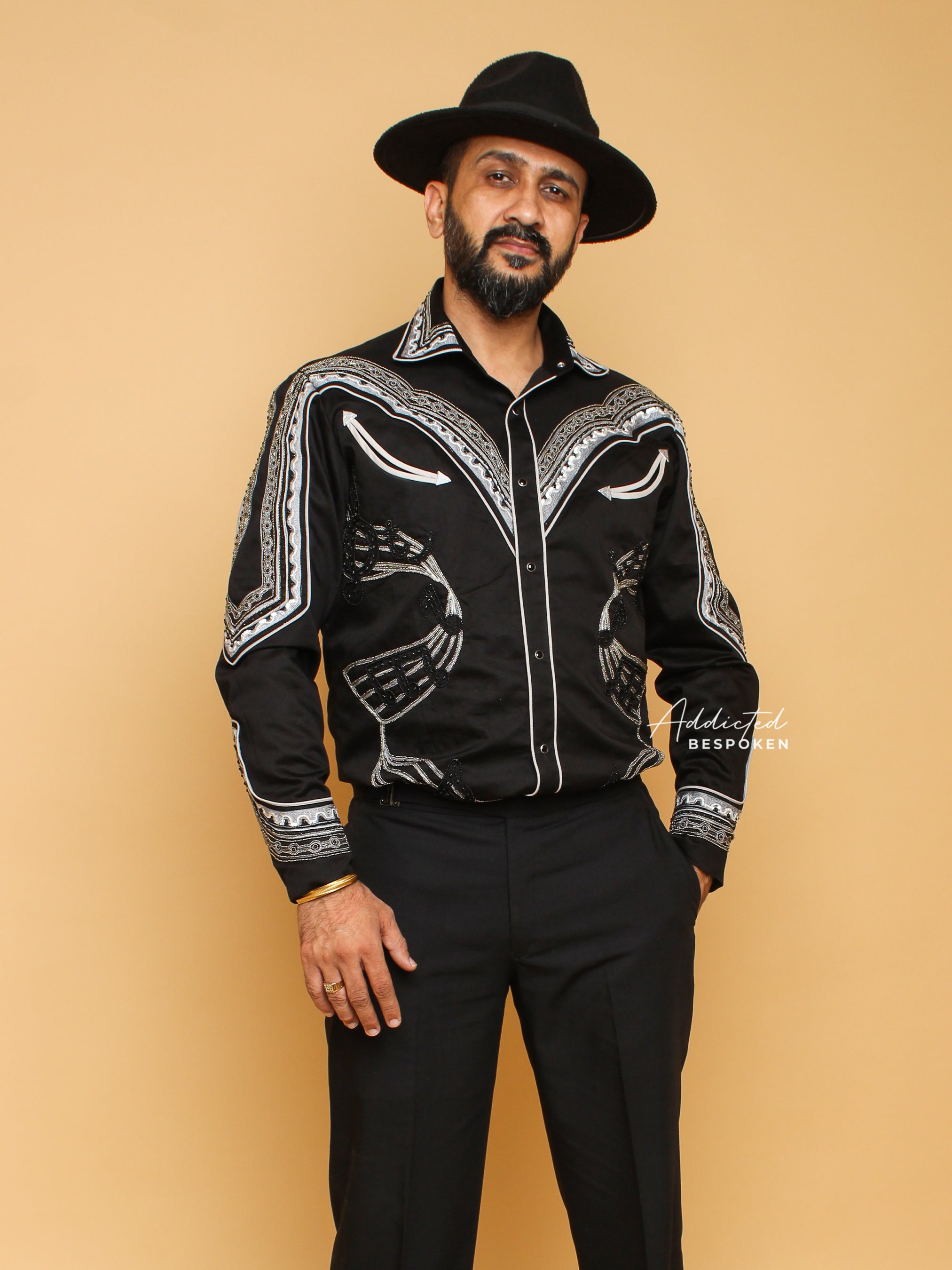 Front view of male model wearing black embroidered western shirt with white stitching and black hat – Addicted Bespoken