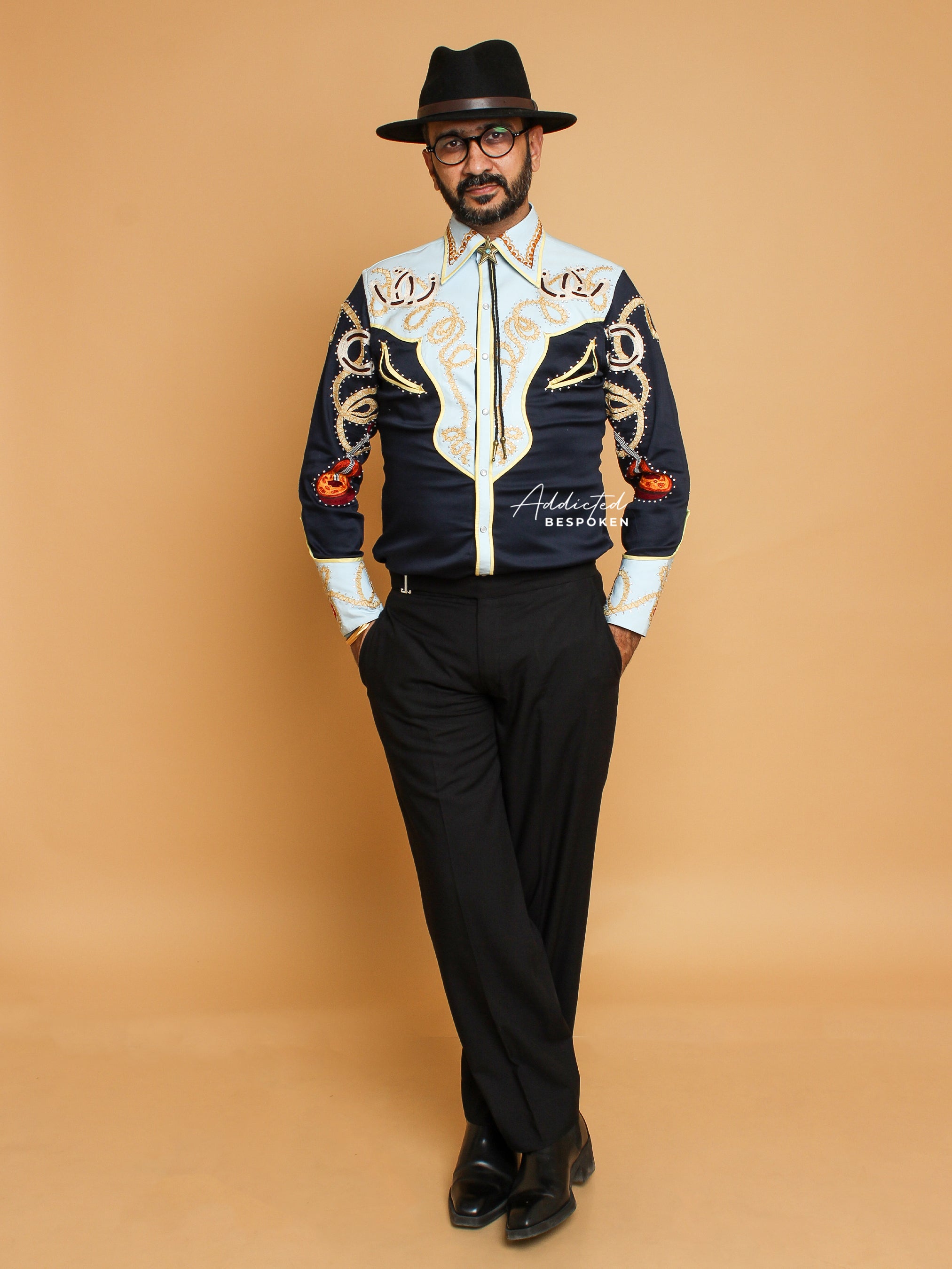 Full body view of male model wearing black and cream western shirt with golden embroidery and black trousers – Addicted Bespoken