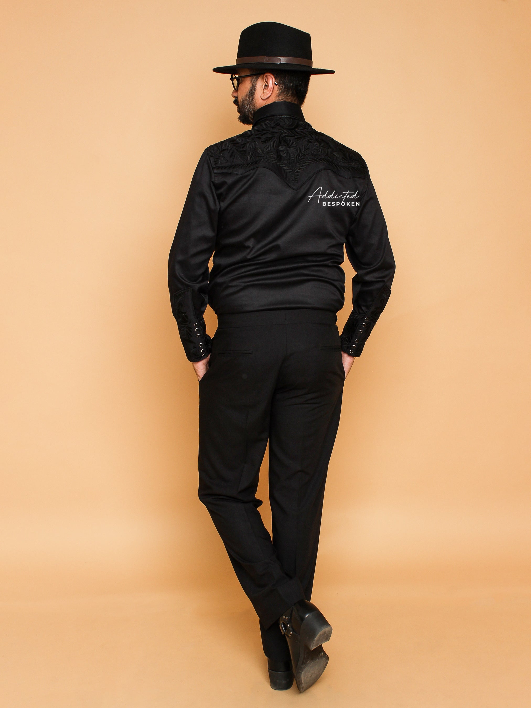 Standing back view of male model in all-black embroidered western shirt and trousers β Addicted Bespoken