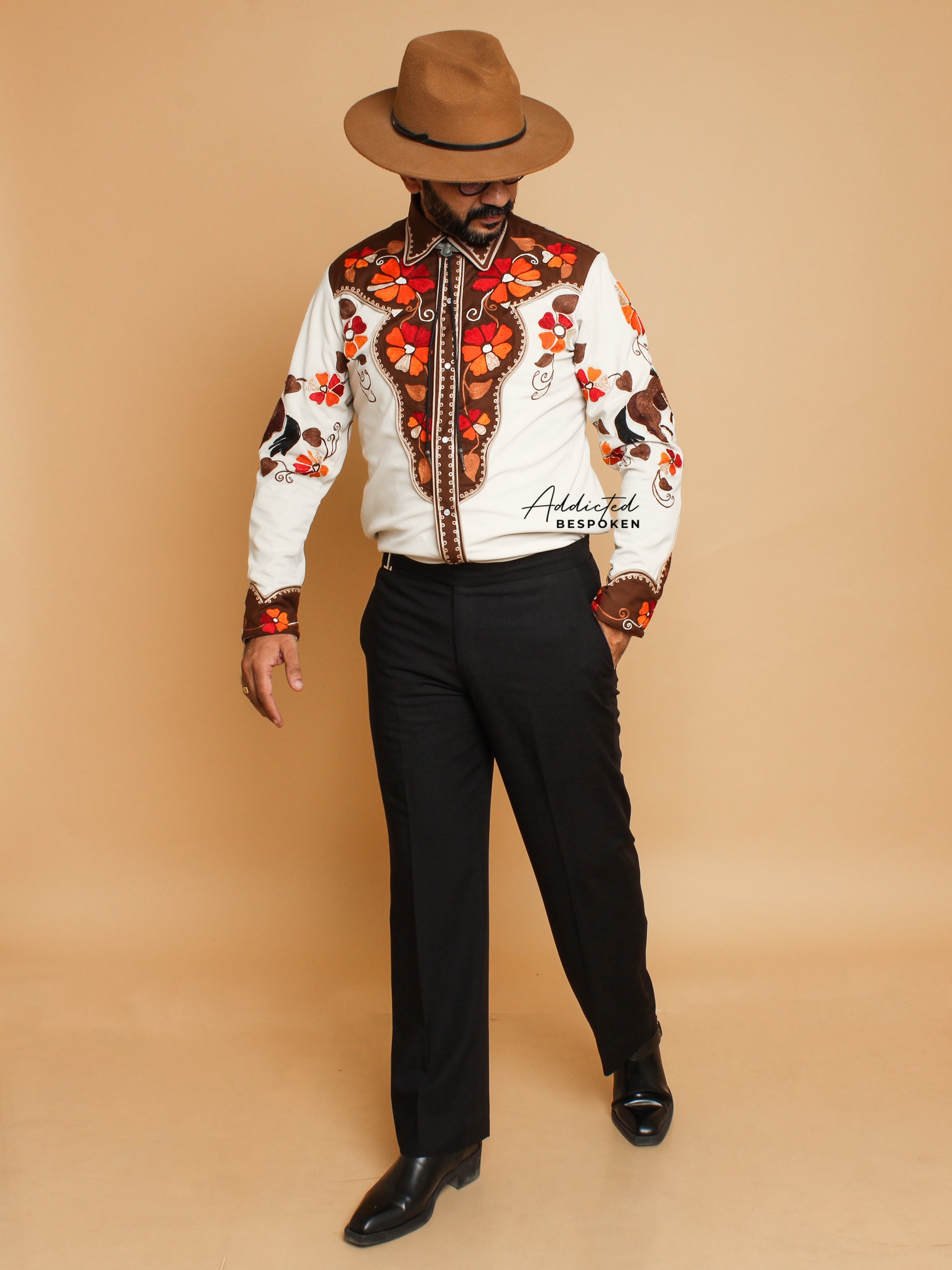 Full body view of male model wearing cream western shirt with red floral embroidery and black trousers – Addicted Bespoken