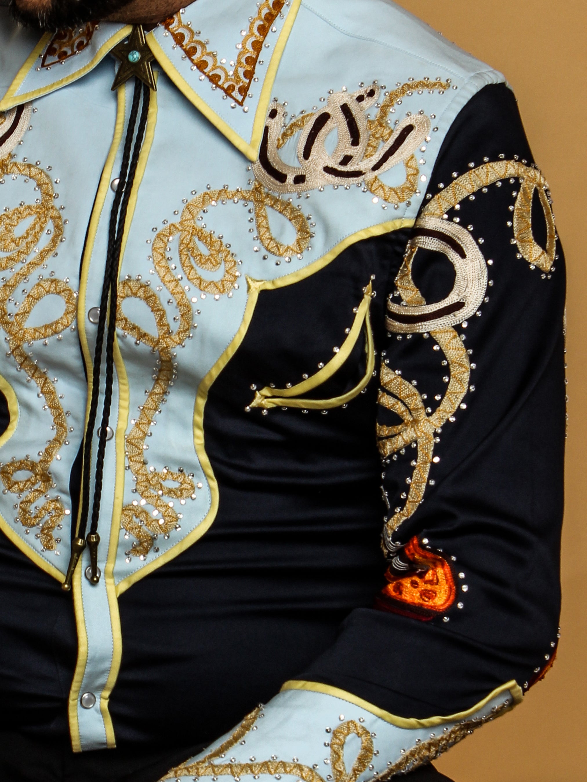 Close-up of ornate golden embroidery on black and cream western shirt – Addicted Bespoken