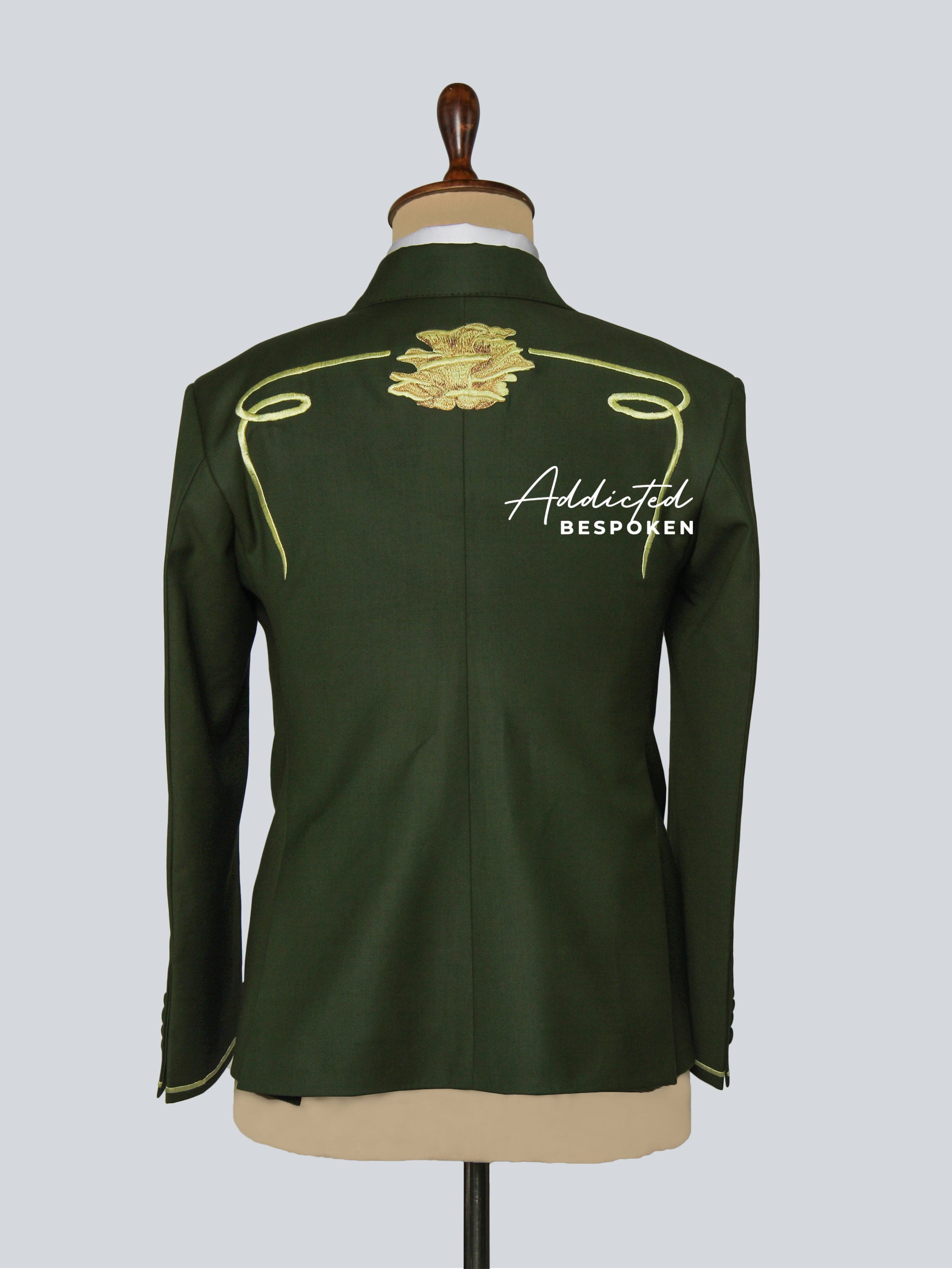 Green jacket with gold accents on a mannequin against a gray background, featuring 'Addicted Bespoke' branding.